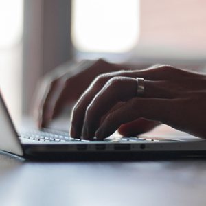 close up of fingers working on a laptop keyboard