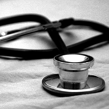 close up of a stethoscope laying on a hospital bed
