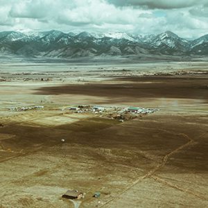 aerial view of a large expanse of undeveloped land at the base of a mountain range with small settlements starting to build